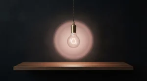Eine einzelne leuchtende Glühlampe steht vor einem dunkelroten Hintergrund